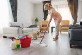 Woman mopping the floor with pet safe cleaning products and disinfectants that won't harm her dog.